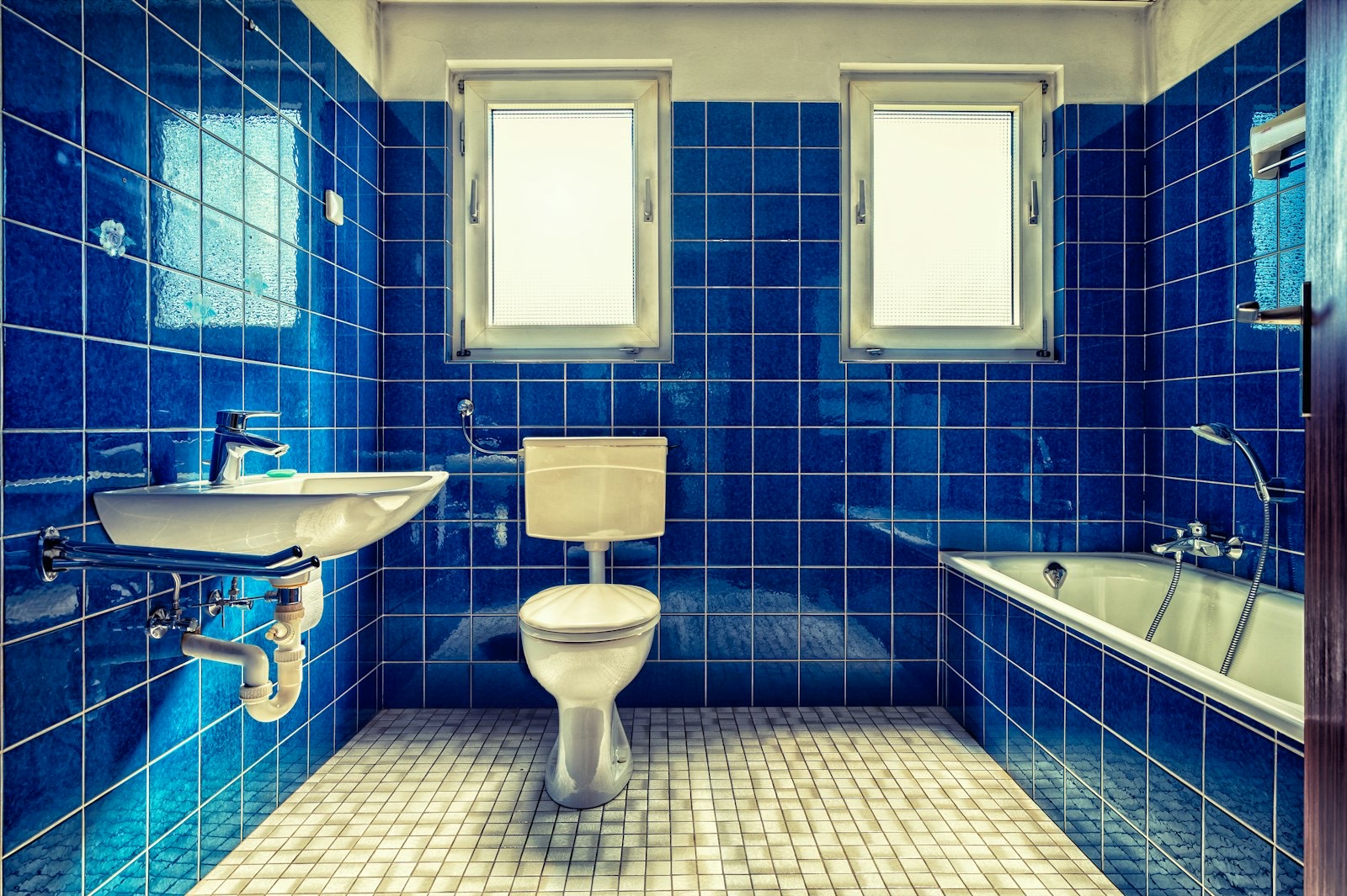Ancienne salle de bains carrelée de bleu, avant rénovation (photo d'illustration)